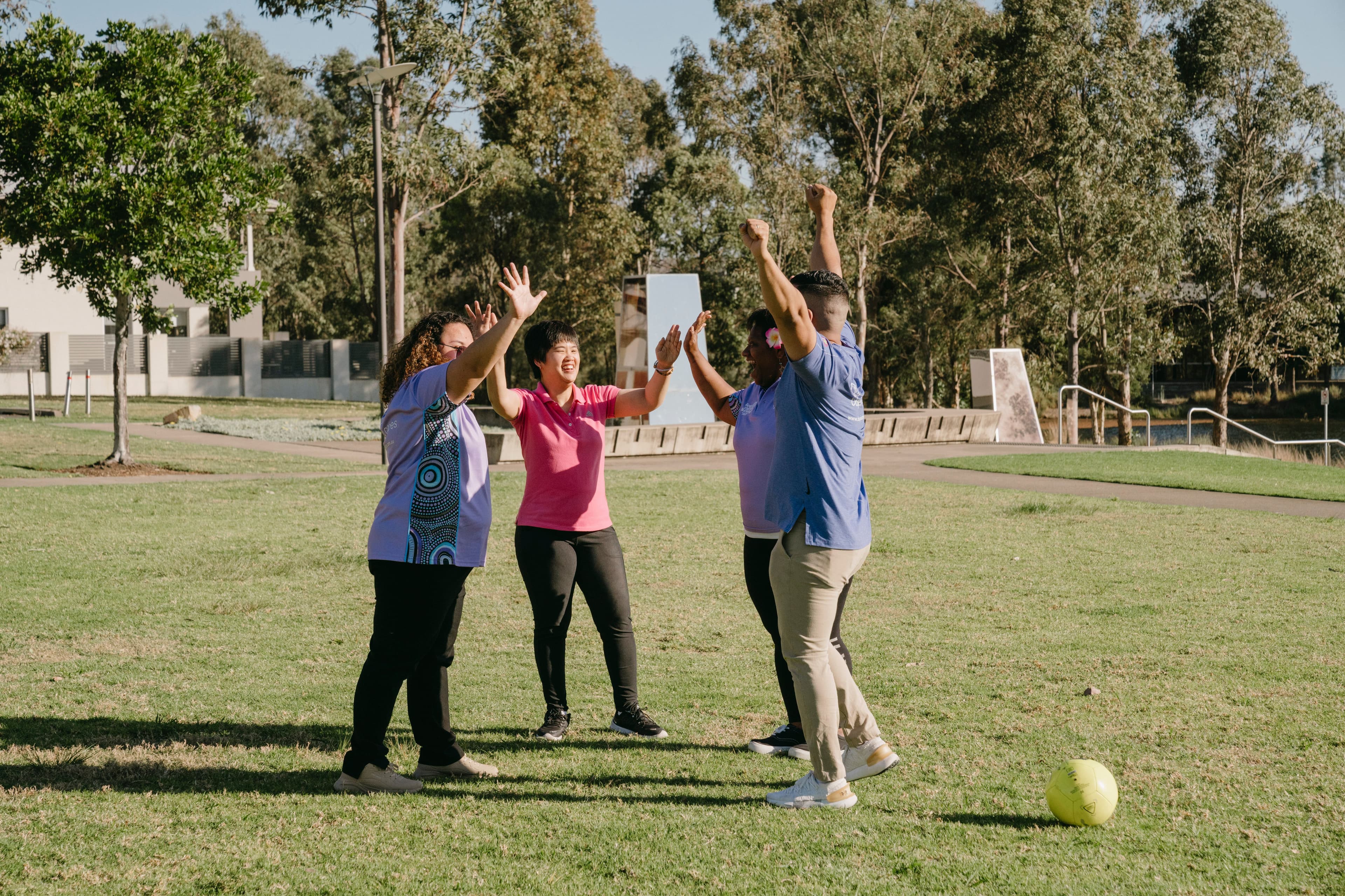 Melissa and 3 other Bopha Cares NDIS workers all come in for a group "Hi-5" after winning a team sport